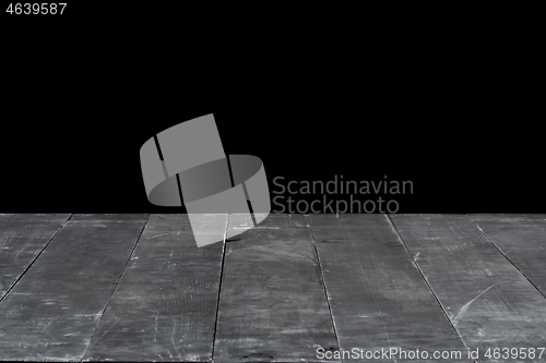 Image of Dark grey wooden table for expose or montage your products on a black background.