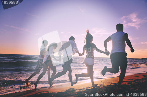 Image of people group running on the beach