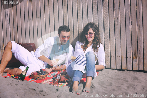 Image of young couple enjoying  picnic on the beach