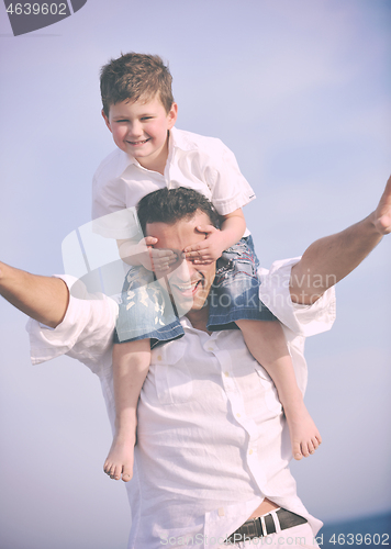 Image of happy father and son have fun and enjoy time on beach