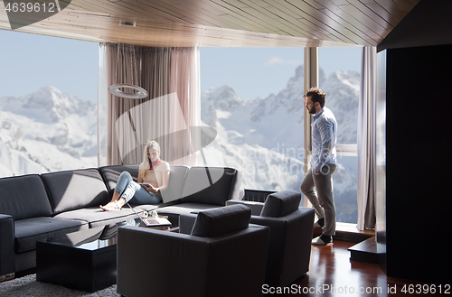 Image of couple relaxing at  home using tablet computer