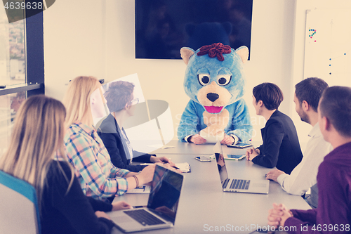 Image of boss dresed as bear having fun with business people in trendy of