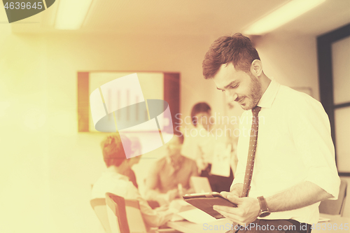 Image of young business man with tablet at office meeting room