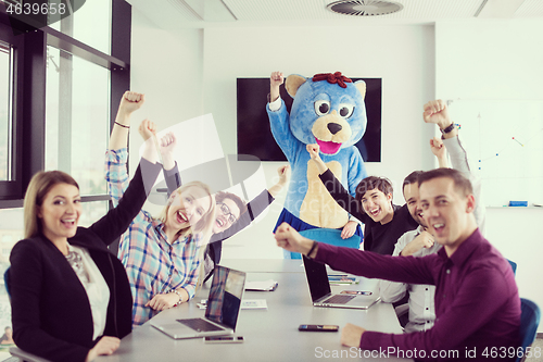 Image of boss dresed as bear having fun with business people in trendy of