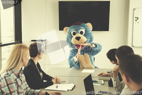 Image of boss dresed as bear having fun with business people in trendy of