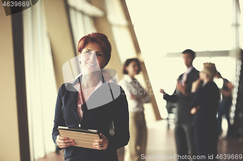 Image of business woman  at office with tablet  in front  as team leader