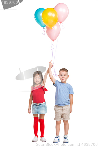 Image of Full length portrait of cute little kids in stylish clothes looking at camera and smiling