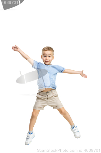 Image of Adorable boy jumping and raises his hands up.