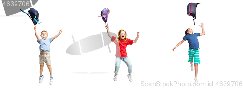 Image of Full length portrait of cute little kids in stylish clothes jumping with bag