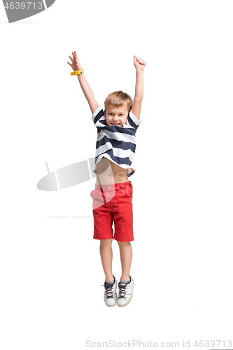 Image of Adorable boy jumping and raises his hands up.