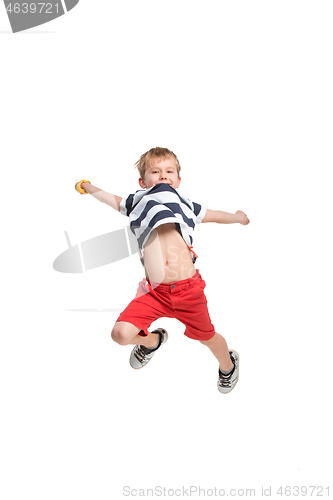 Image of Adorable boy jumping and raises his hands up.