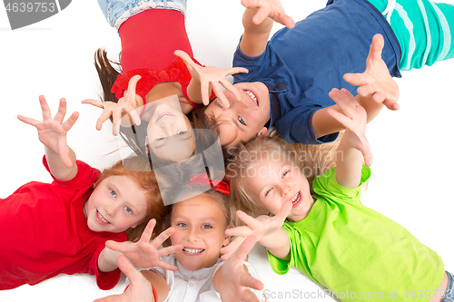 Image of Close-up of happy children lying on floor in studio and looking up