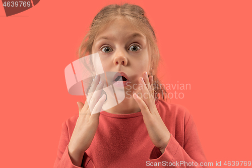 Image of Cute little surprised girl in coral dress with long hair smiling to camera