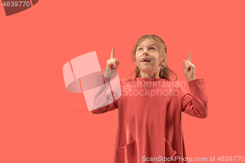 Image of Cute little surprised girl in coral dress with long hair smiling to camera