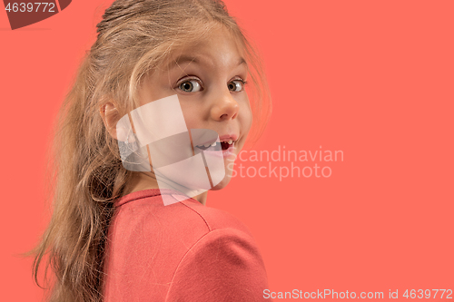 Image of Cute little girl in coral dress with long hair smiling to camera