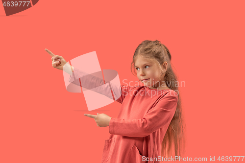 Image of Cute little surprised girl in coral dress with long hair smiling to camera