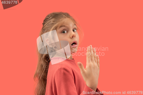 Image of Cute little surprised girl in coral dress with long hair smiling to camera