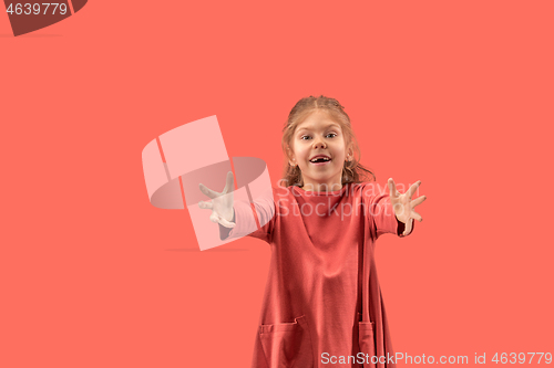 Image of Cute little girl in coral dress with long hair smiling to camera