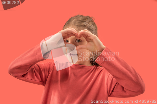 Image of young girl forming a heart with her fingers