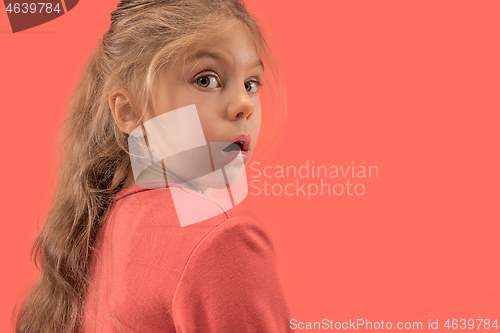 Image of Cute little surprised girl in coral dress with long hair smiling to camera