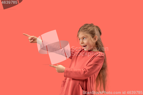 Image of Cute little surprised girl in coral dress with long hair smiling to camera