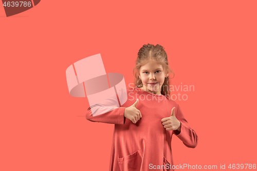 Image of Cute little girl in coral dress with long hair smiling to camera