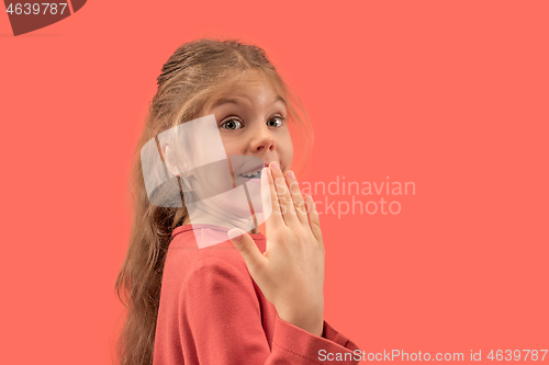 Image of Cute little surprised girl in coral dress with long hair smiling to camera