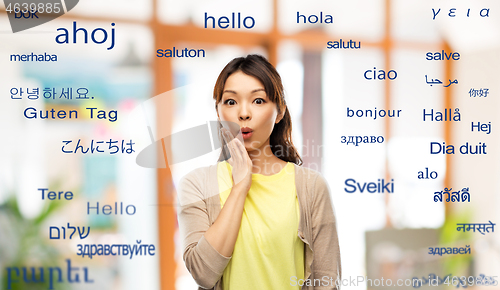 Image of surprised asian woman over foreign words