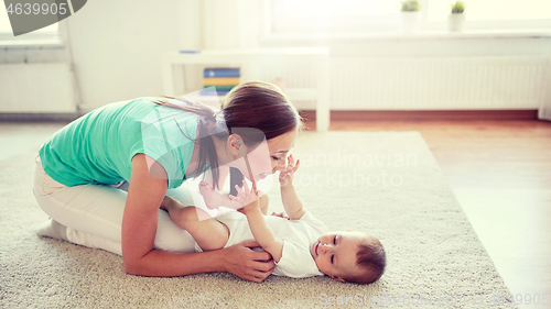 Image of happy mother playing with baby at home