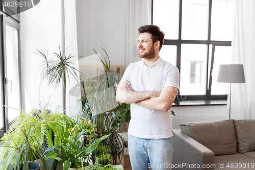 Image of smiling man with houseplants at home