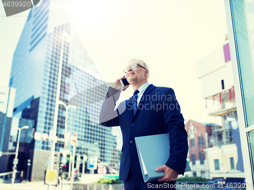 Image of senior businessman calling on smartphone in city