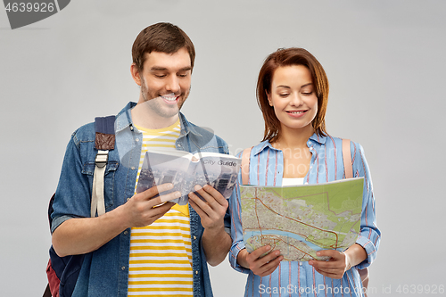 Image of happy couple of tourists with city guide and map