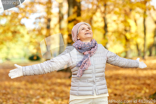 Image of happy senior woman enjoying beautiful autumn