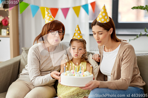 Image of mother, daughter, grandmother with birthday cake