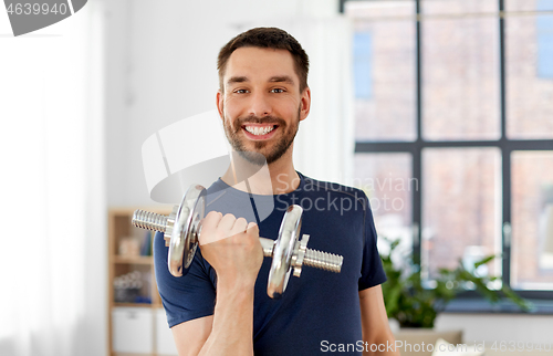 Image of man exercising with dumbbell at home