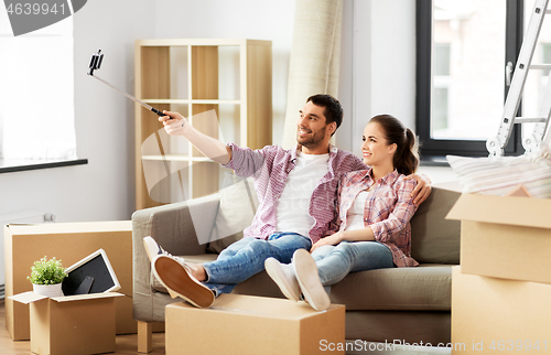 Image of couple taking picture by selfie stick at new home