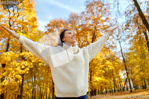 Image of beautiful happy young woman in autumn park