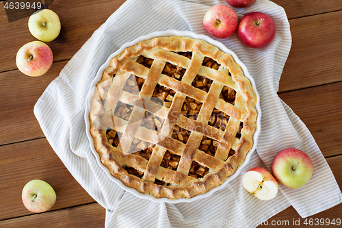 Image of apple pie in baking mold on wooden table