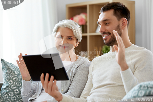 Image of old mother and adult son with tablet pc at home