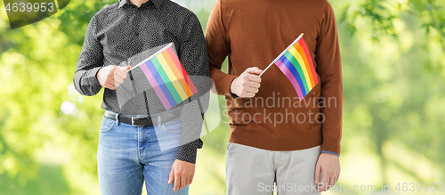 Image of close up of male couple with gay pride flags