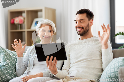 Image of old mother and adult son with tablet pc at home