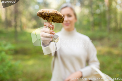 Image of young woman with mushroom in autumn forest