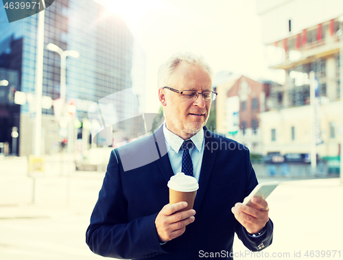 Image of businessman with smartphone and coffee in city