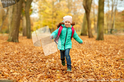 Image of happy student girl with schoolbag at autumn park