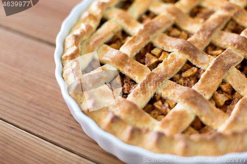 Image of close up of apple pie in mold on wooden table