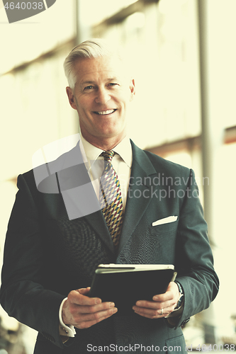 Image of senior business man working on tablet computer