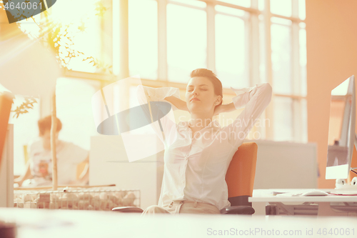 Image of young business woman relaxing at workplace