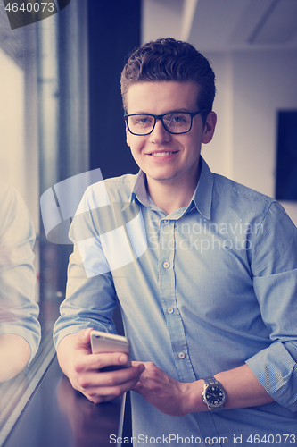 Image of Businessman Standing In A Modern Building Near The Window With P