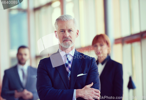 Image of senior business man with his team at office