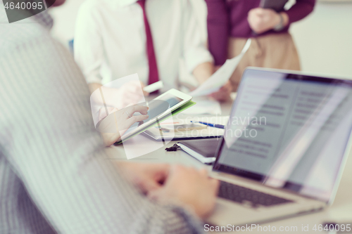 Image of close up of  businessman hands  using tablet on meeting